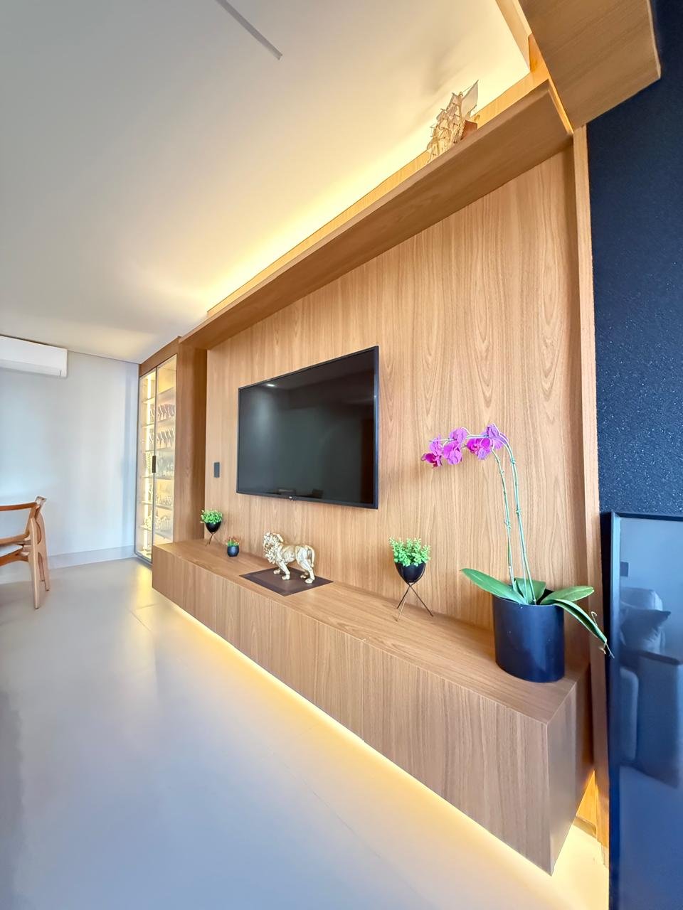Painel de sala em madeira com iluminação indireta